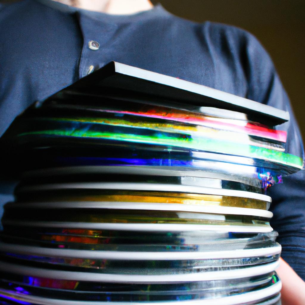 Person holding stack of DVDs